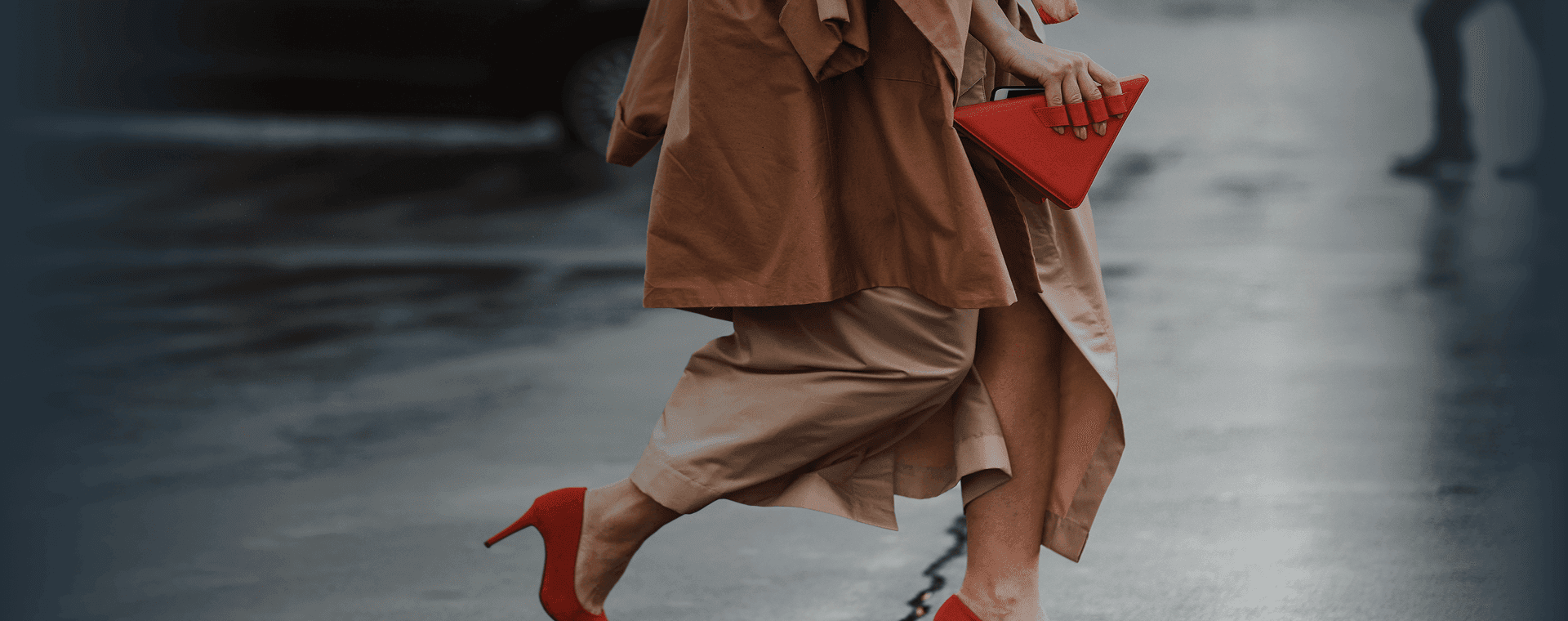 Una donna ben vestita, con dei bellissimi tacchi rossi e una borsa rossa alla moda, attraversa la strada. Sovrapposta la frase francese "bien habillé" con la sua traduzione in italiano, "ben vestita".