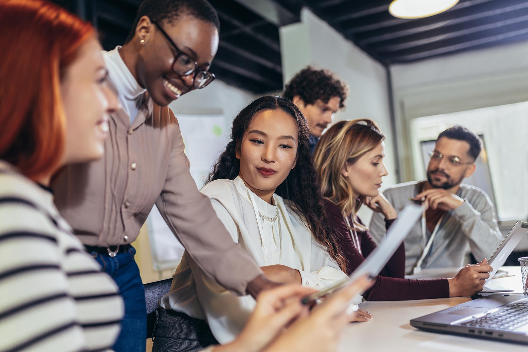 Un gruppo di professionisti durante una riunione; rappresentano i programmi di apprendimento linguistico di Rosetta Stone per le aziende, volti a migliorare la comunicazione e le competenze sul posto di lavoro.