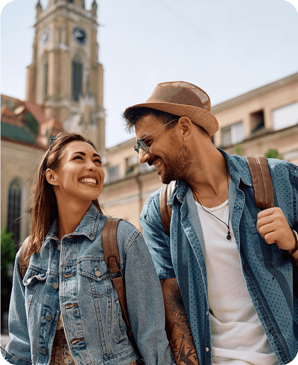 Una coppia sorridente che cammina all'aperto, a rappresentare l'uso della lingua nella vita di tutti i giorni.