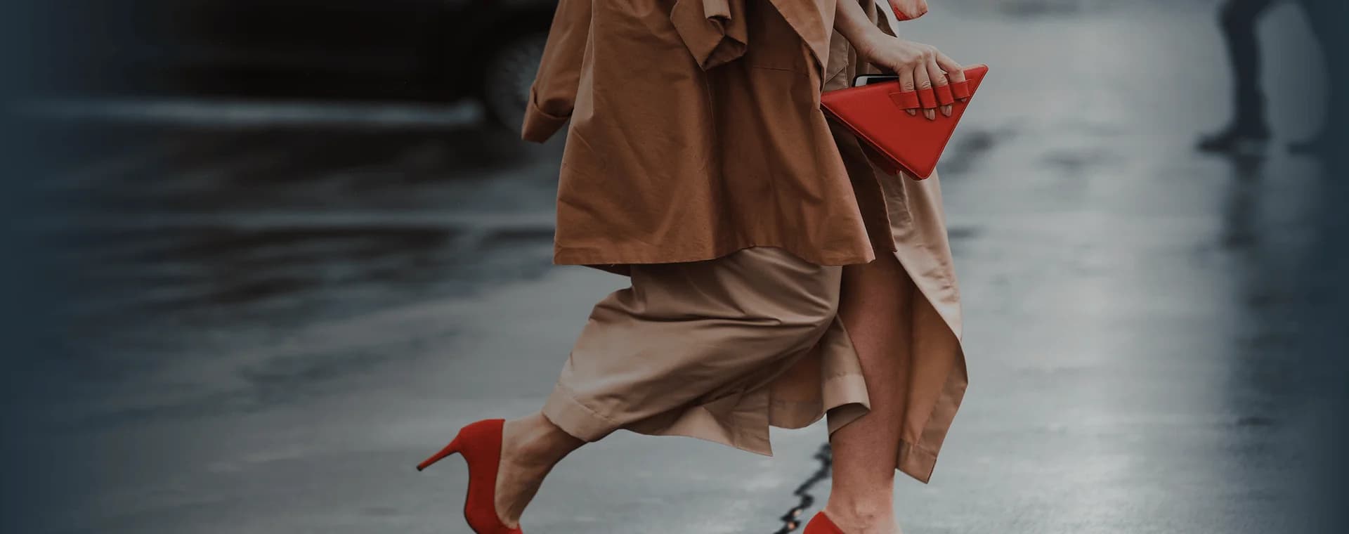 Una donna ben vestita, con dei bellissimi tacchi rossi e una borsa rossa alla moda, attraversa la strada. Sovrapposta la frase francese "bien habillé" con la sua traduzione in italiano, "ben vestita".