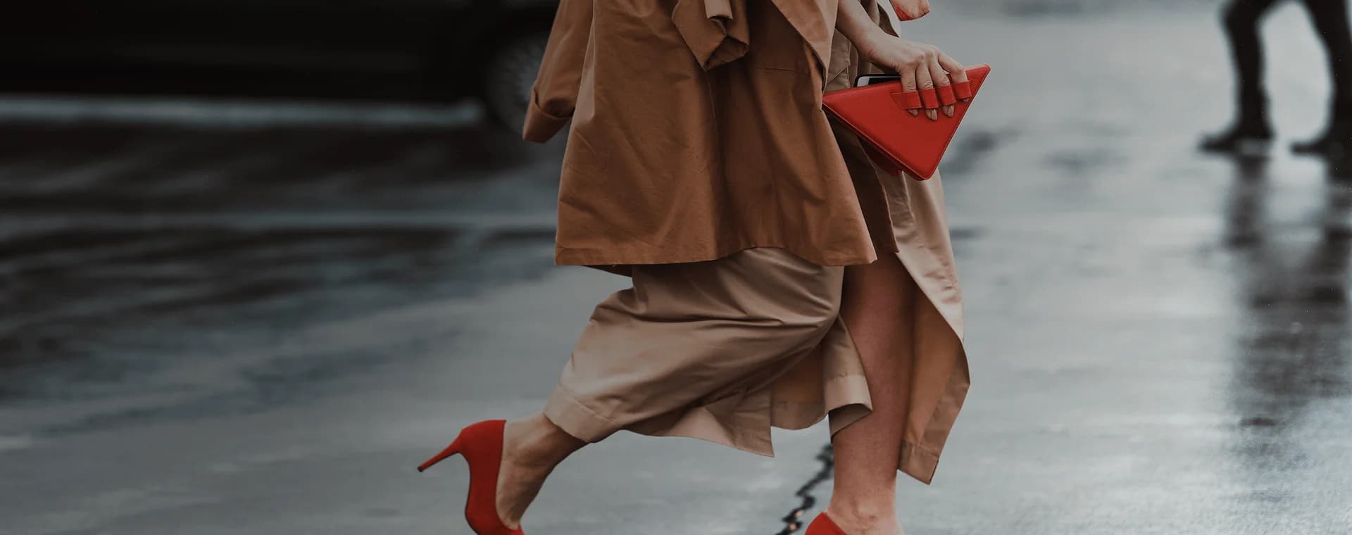 Una donna ben vestita, con dei bellissimi tacchi rossi e una borsa rossa alla moda, attraversa la strada. Sovrapposta la frase francese "bien habillé" con la sua traduzione in italiano, "ben vestita".